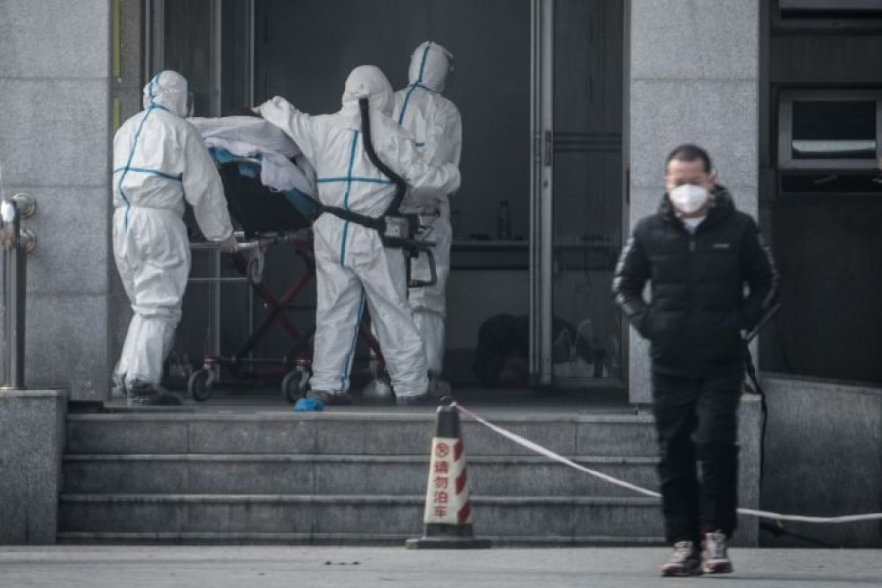 Kiinan Wuhanissa sairaalahenkilökunta vei potilasta sairaalaan, jossa hoidetaan viruksen saaneita. LEHTIKUVA / AFP