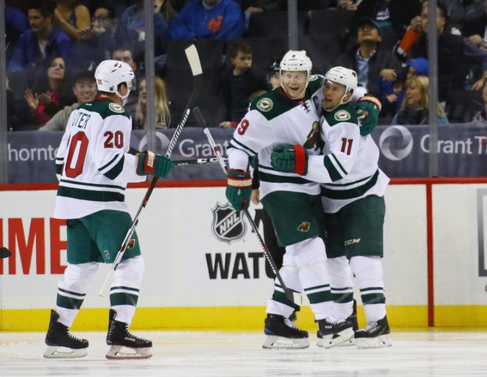 Minnesotan Ryan Suter ja Mikko Koivu onnittelevat Zach Parisea uran 300. NHL-maalista. New York Islanders kuitenkin voitti ottelun maalein 6-3. LEHTIKUVA/AFP
