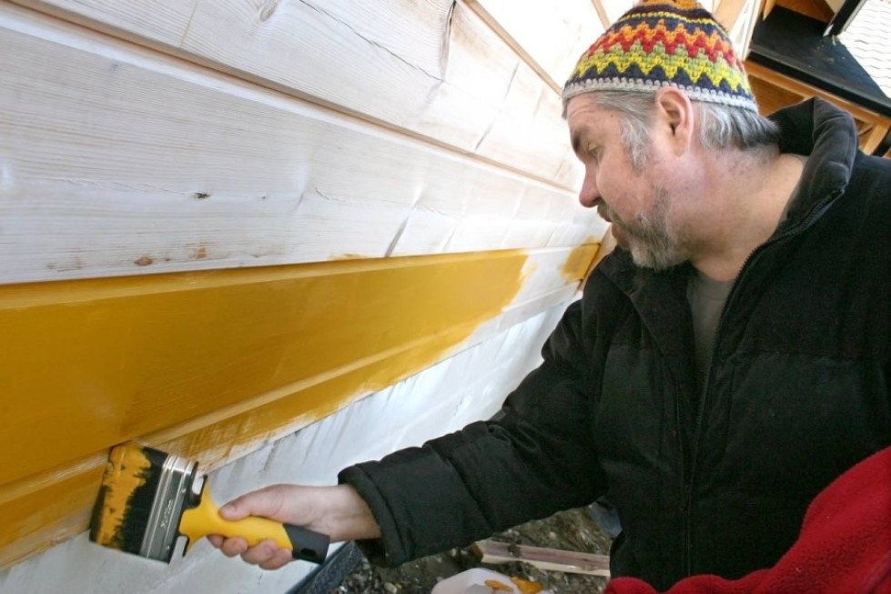 Juha Kainulainen testasi keittämäänsä keltamultamaalia hirsitalon seinään toukokuussa Liperissä. Talo maalattiin talkoilla kahteen kertaan kahdessa päivässä.