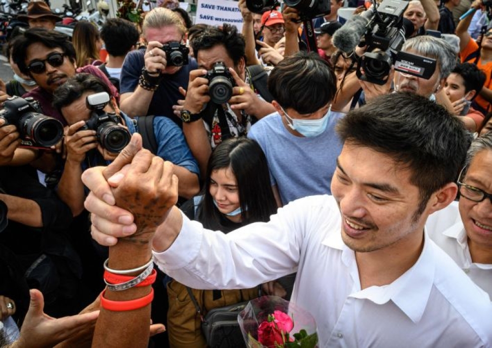 Mielenilmauksen järjesti miljardööri Thanathorn Juangroongruangkit, joka kuvassa kättelee tukijaansa poliisilaitoksen edustalla Bangkokissa perjantaina. Lehtikuva/AFP