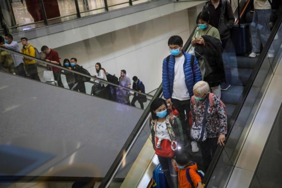 Hongkongin lentokentällä matkailijat käyttivät torstaina kasvomaskeja suojautuakseen virukselta. LEHTIKUVA/AFP