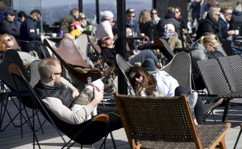 Ihmisiä terassilla nauttimassa lämpimästä kevätsäästä Eiranrannassa pääsiäissunnuntaina. LEHTIKUVA / MARKKU ULANDER