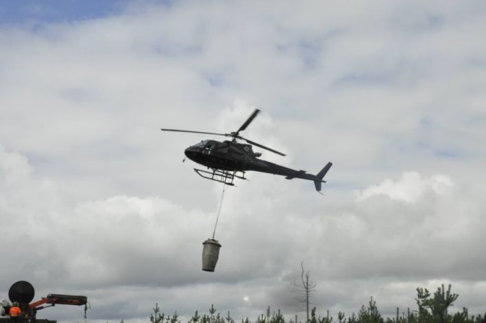 Tuhkalannoite voidaan levittää metsään helikopterilla.