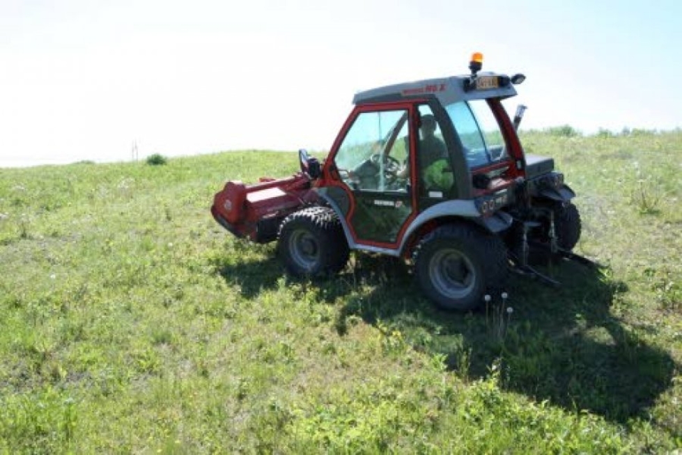 Urakoitsija Martti Ikosen uudella niittokoneella pystyy leikkaamaan tienpientareet häiritsemättä liikennettä. Matala painopiste mahdollistaa myös kallellaan ajamisen hankalassa maastossa.