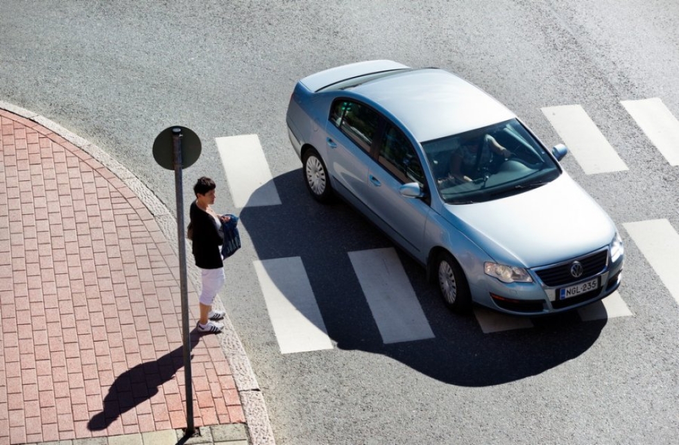 Jalankulkija odottaa nöyrästi, että vaaleansininen Volkswagen Passat kiihdyttää ensin suojatien yli Torikadulla.