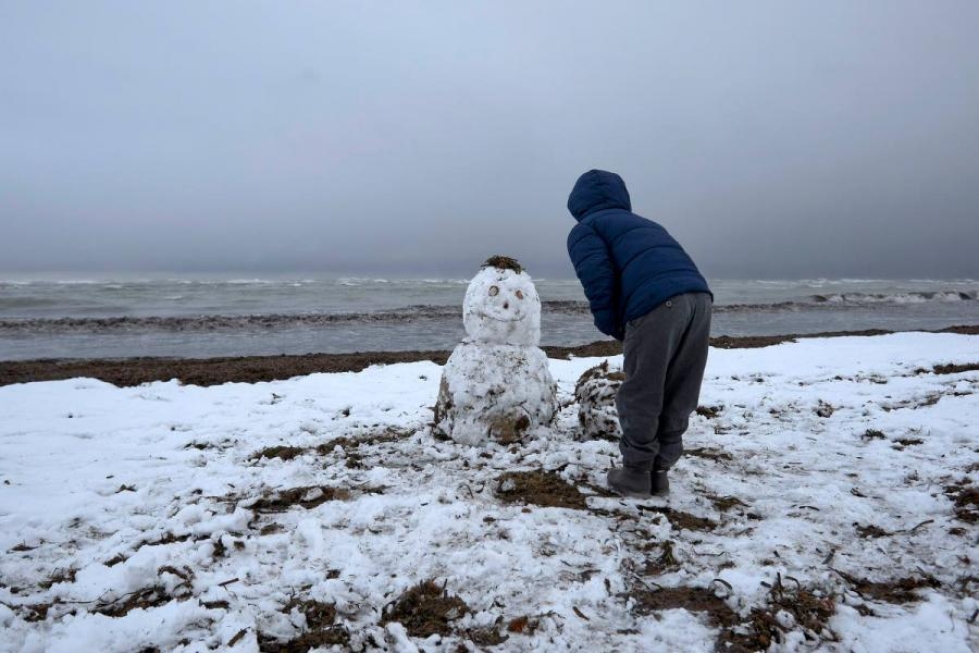 Poika rakensi lumiukon Denian rannalla Alicantessa. Deniassa satoi viimeksi lunta vuonna 1983.