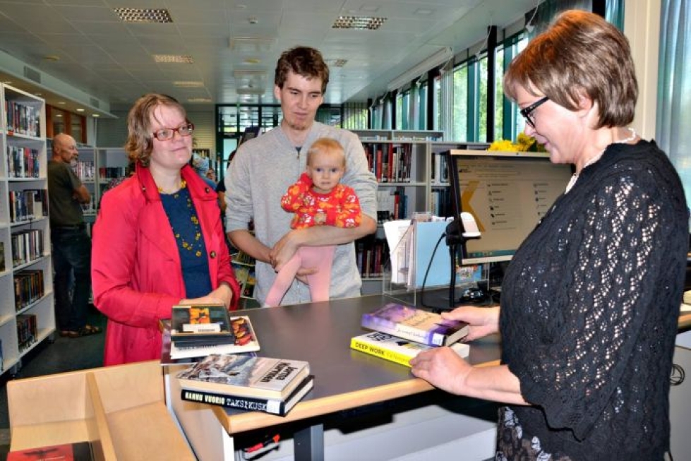 Paula ja Miikka Vuorela Armi-tyttärensä kanssa palauttivat kassillisen kirjoja Lahja Ruottiselle ennen kuin lainasivat uutta luettavaa.