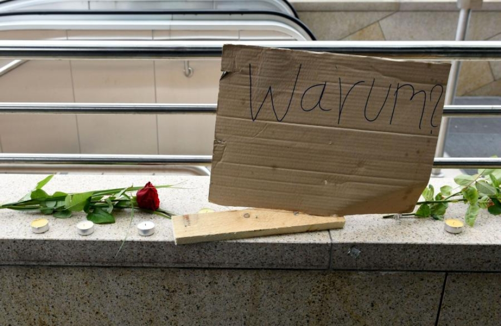 Miksi? kysytään pahviin kirjoitetussa tekstissä, joka oli sijoitettu ruusujen kanssa Münchenin ostoskeskuksen läheisyyteen tänään. Ostoskeskuksen joukkoampumisessa kuoli epäilty ampuja ja yhdeksän muuta ihmistä. LEHTIKUVA/AFP