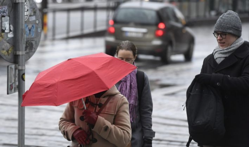 Etelässä sateet tulevat pääosin vetenä tai tihkuna. Jalankukija sateenvarjon suojassa Helsingissä tammikuussa. LEHTIKUVA / HEIKKI SAUKKOMAA