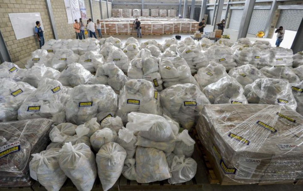 Yhdysvallat on jo toimittanut kymmenien tonnien edestä apua Kolumbiaan odottamaan pääsyä rajan yli. LEHTIKUVA/AFP