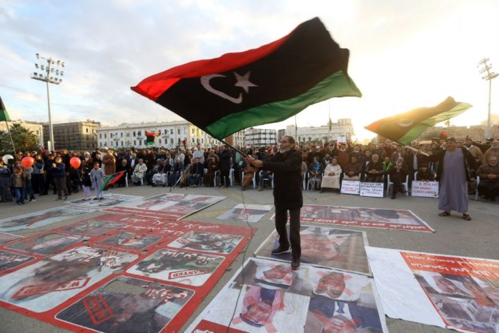 Mielenosoittaja heilutti Libyan lippua maan pääkaupungissa Tripolissa 10. tammikuuta. LEHTIKUVA / AFP