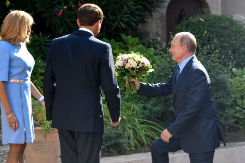 Ranskassa vieraileva presidentti Vladimir Putin ojensi kukkia Ranskan presidentin puolisolle Brigitte Macronille. LEHTIKUVA/AFP