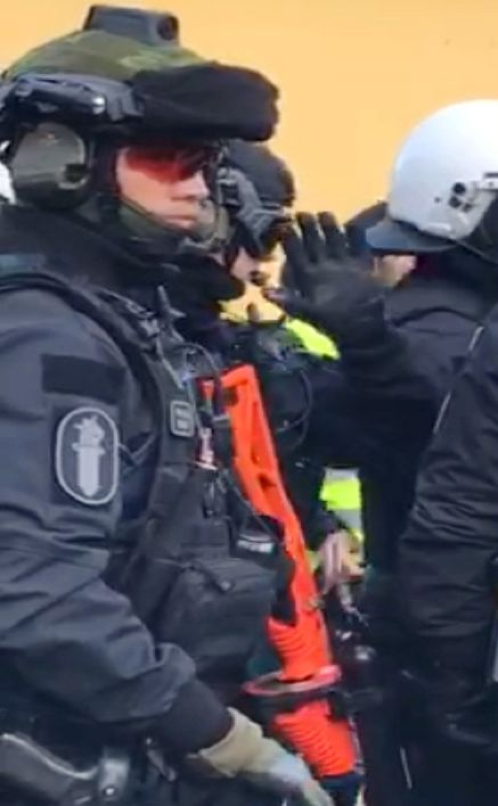 Poliisi varustautuneena projektiiliaseella eli paineilma-aseella lauantain Turkki-mielenosoituksessa Narinkkatorilla Helsingissä. Kuvakaappaus STT:n haltuunsa saamalta videolta. LEHTIKUVA/HANDOUT