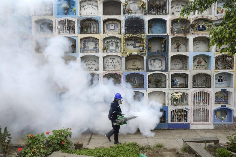 Hyttysiä savustettiin Nueva Esperanzan hautausmaalla Perun pääkaupungissa Limassa heinäkuussa. LEHTIKUVA/AFP