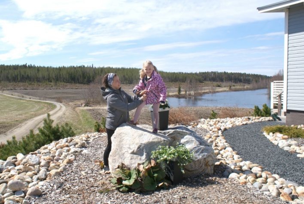 Henna Nevalainen ja Iida-tytär kuusi vuotta sitten laitetulla hake- ja kivipihalla. Kukat kasvavat kätevästi ruukuissa.