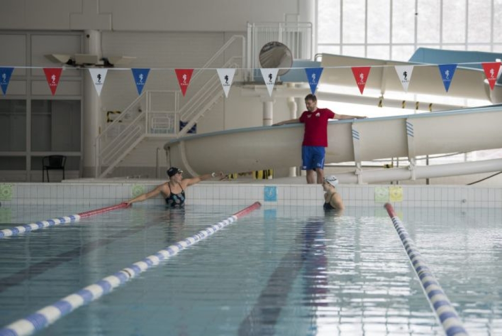 Valmentaja Jere Jännes seuraa altaan reunalta kun Jenna Laukkanen ja Ida Hulkko harjoittelevat suljetussa Vuokatin urheiluopiston uimahallissa. LEHTIKUVA / KIMMO RAUATMAA