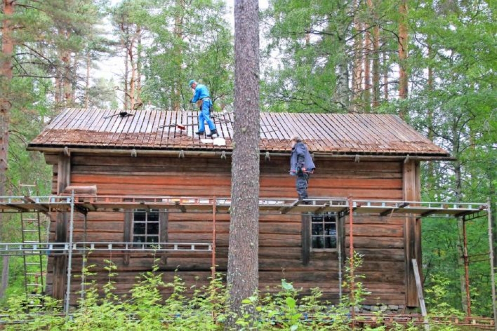 Savutuvan katolla harjamiehenä Keijo Luukkainen ja tellingeillä Pentti Ojajärvi. Puhdistetun laudoituksen päälle tulee pitkät parrut, malat.